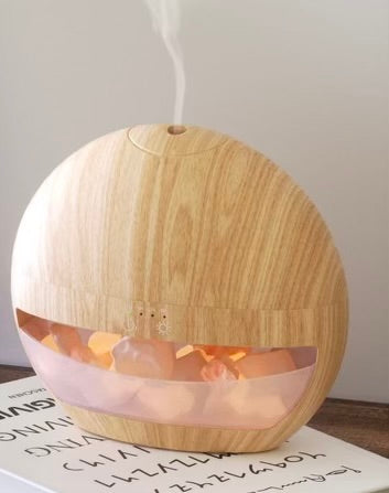 Wooden diffuser emitting steam on a white surface