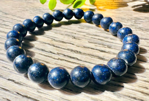 Blue beaded bracelet on a wooden surface with a blurred background
