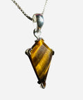 Tiger's eye pendant on a silver chain against a white background