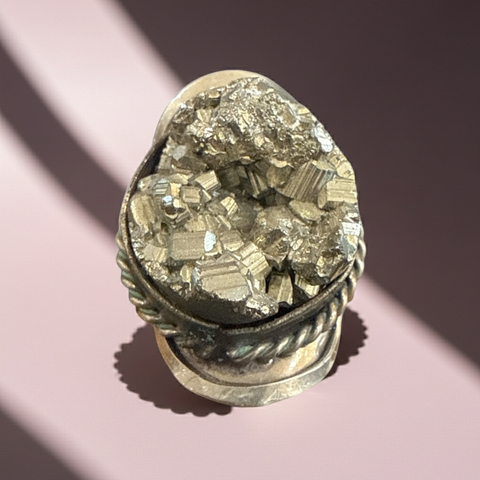 Statement ring with an adjustable band and an unpolished raw pyrite crystal centerpiece.