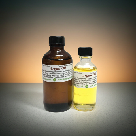 Amber glass bottle of argan carrier oil with dropper on a clean white background.