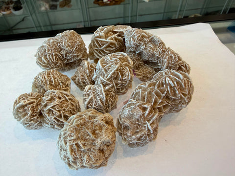 Collection of raw Desert Rose specimens with varied tan coloring and petal patterns