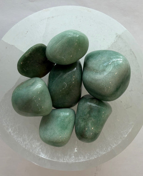Fuchsite Tumbled Stones displayed in a selenite bowl — natural green crystal for emotional healing and self-care.