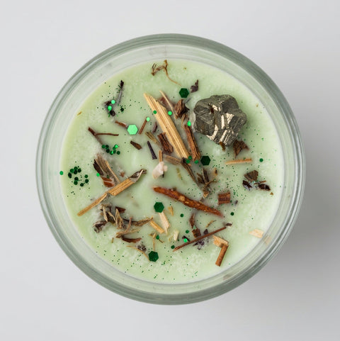 Money Magnet Intention Candle top view – dried botanicals, green sparkle and raw pyrite crystal