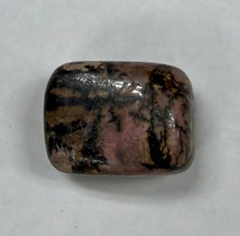 Natural rhodonite tumbled pocket stone for carrying during meditation, calming, and personal energy support.