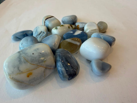 Group of polished blue opal tumbled stones in soft powder-blue, white, and grey