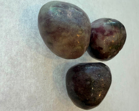 Three polished Kunzite stones showing natural purple color variation
