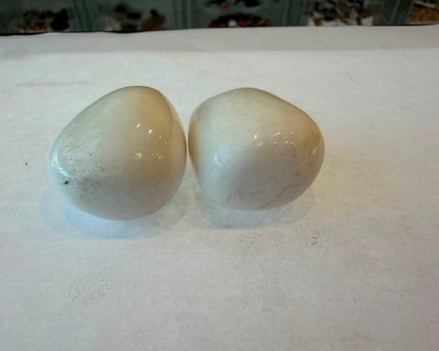 Polished Milky Quartz palm stone showing creamy white translucency