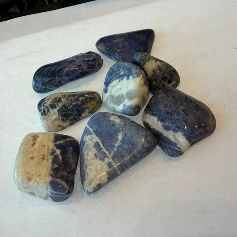Polished sodalite tumbled stone in deep royal blue with white veining