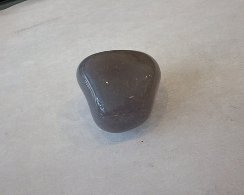 Single polished Tan Chalcedony stone with smooth glossy grey-tan surface