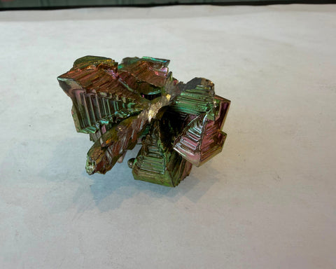 Bismuth crystal side view with vivid green and pink iridescent stepped edges