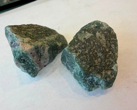 Two raw Green Aventurine stones showing natural variation in green coloring and speckling
