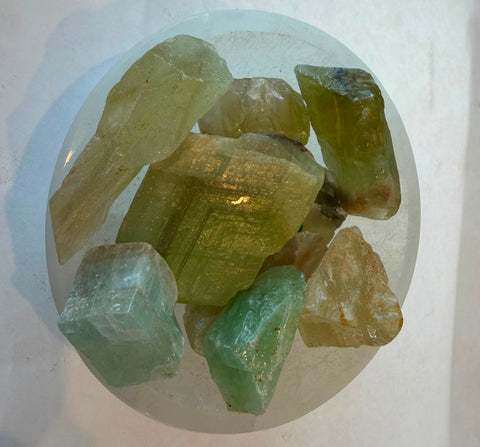 Group of raw green fluorite stones showing translucent mint and olive tones