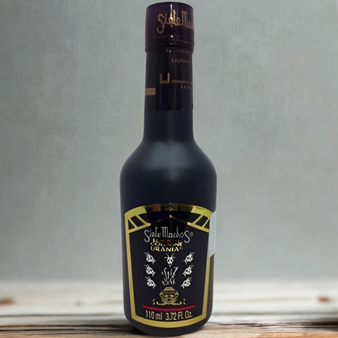 Bottle of Sella Mace's Umbria olive oil on a wooden surface with a gray background