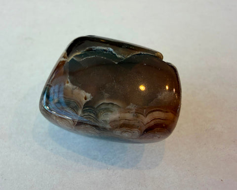 Tumbled Rhodochrosite stone with natural banded pattern and smooth finish