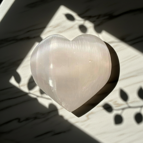 White Selenite heart stone for chakra cleansing, calming meditation, and crystal healing practice.