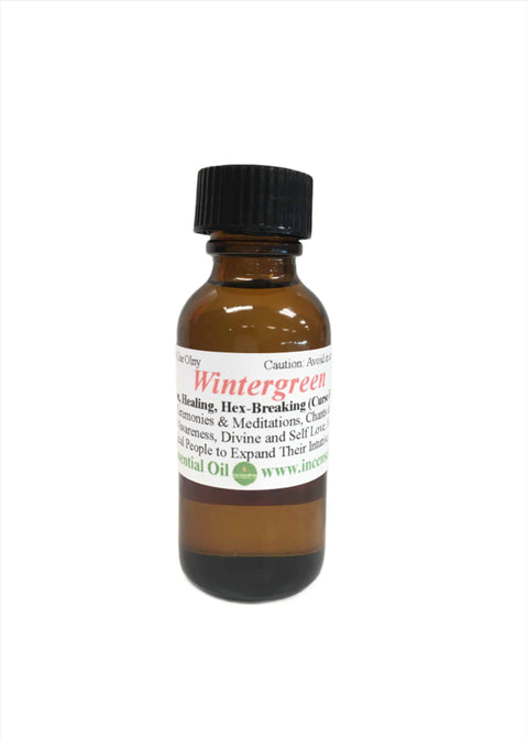 Wintergreen Essential Oil in amber glass bottle with wintergreen leaves and berries