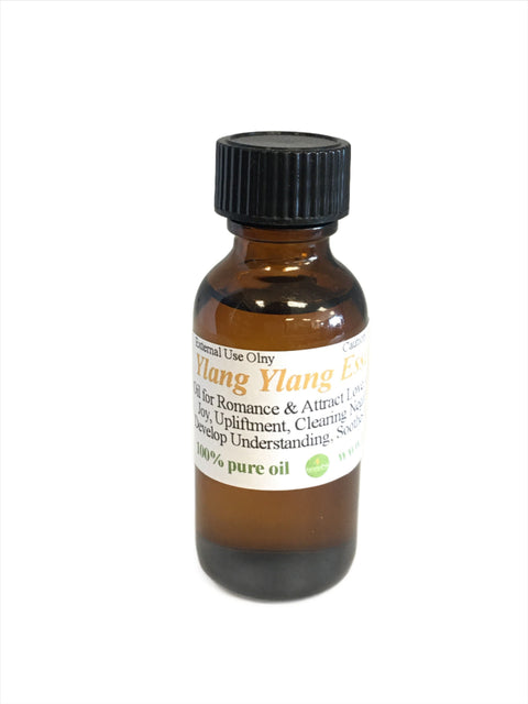 Ylang-Ylang Essential Oil in amber glass bottle with yellow ylang-ylang flowers